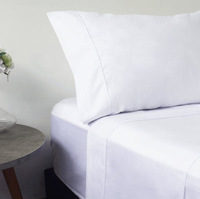 Sábanas premium de algodón importado color blanco impecable sobre cama elegante tipo hotel, mostrando textura suave y diseño de lujo.